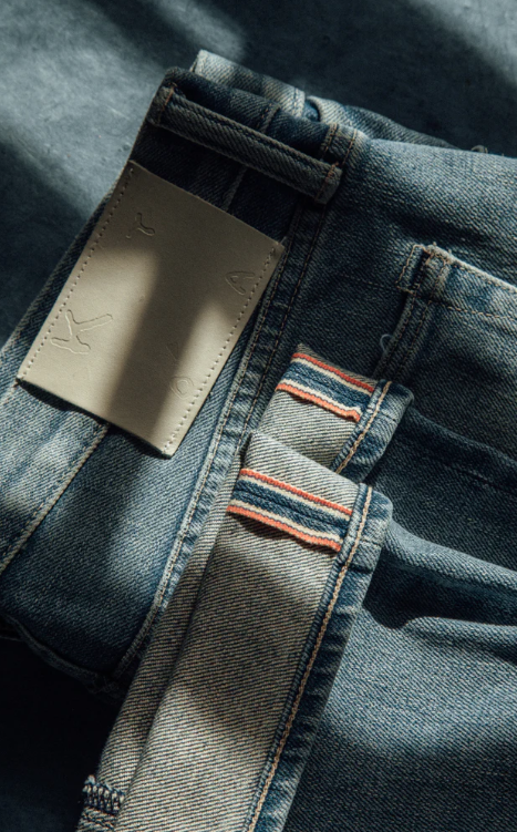Close-up of a blue denim pocket with a brand label.