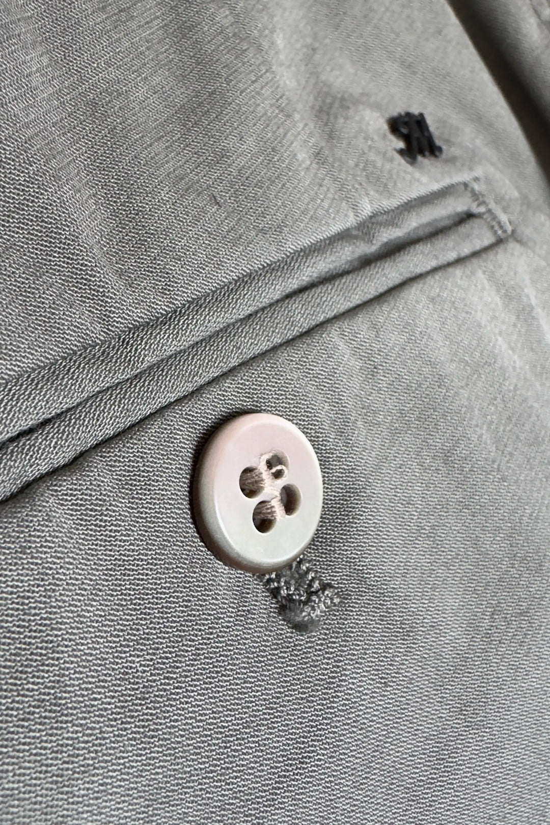 Close-up of a button on gray fabric with a zipper
