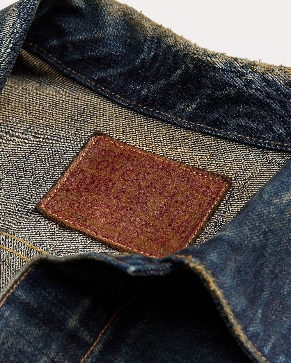 Close-up of a denim fabric with a brand label on a white background