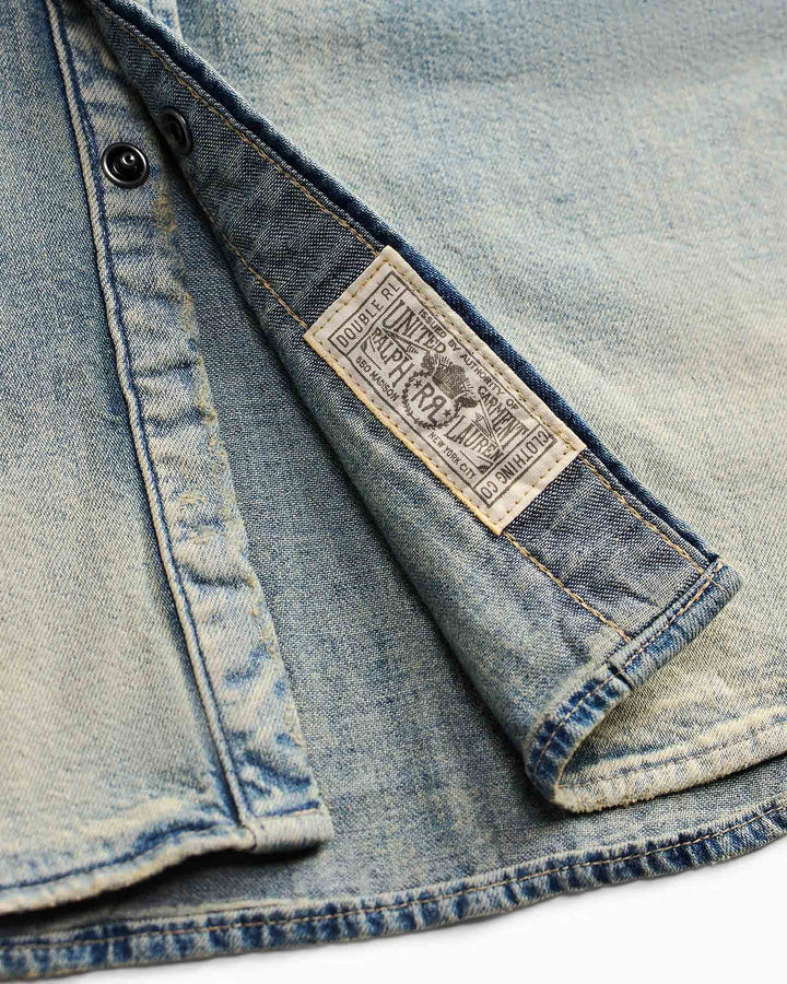 Close-up of a denim jacket with a brand label on a white background