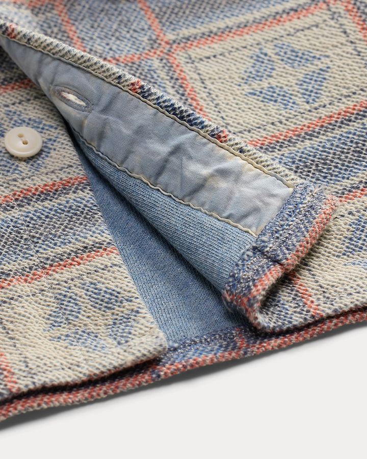 Close-up of a denim jacket with a patterned design on a white background