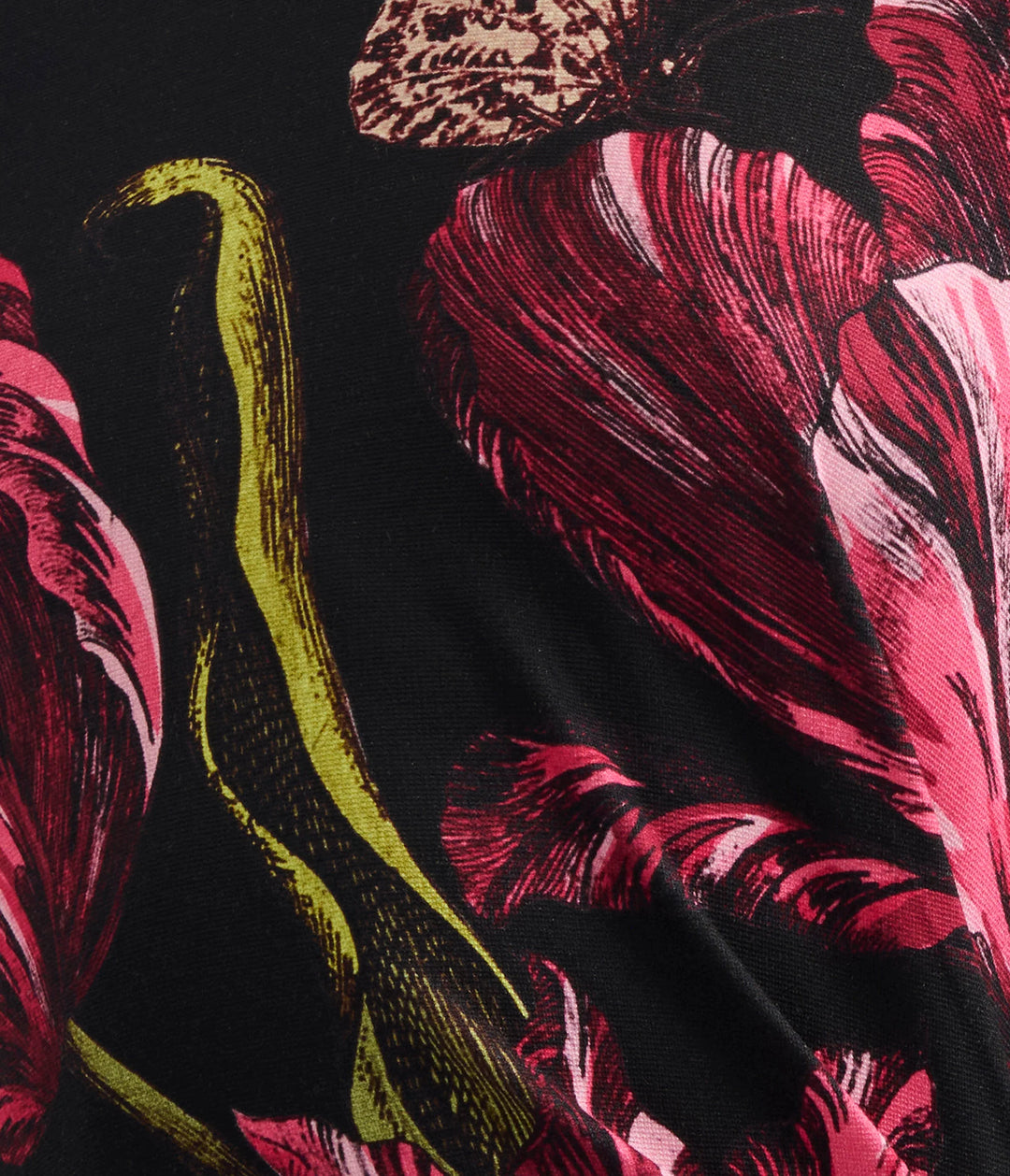 Close-up of a fabric with pink floral and green snake design on black background