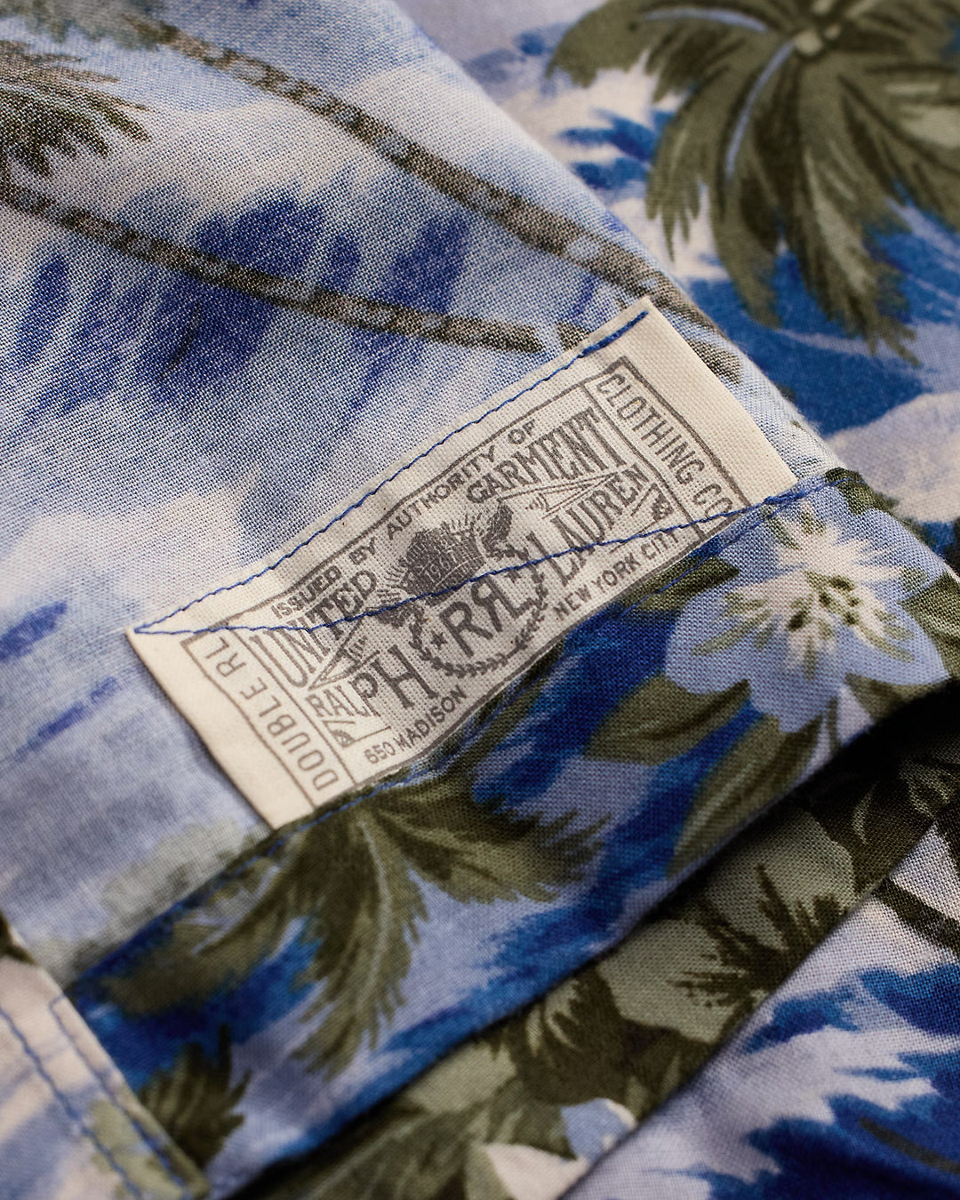 Close-up of a floral-patterned shirt with a brand label.