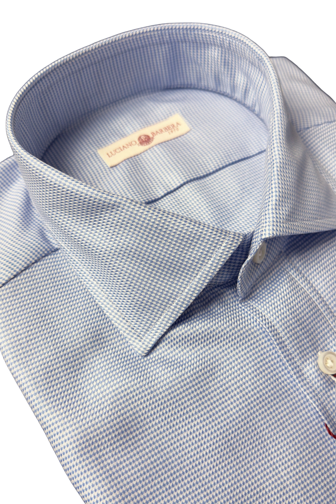 Close-up of a light blue and white micro-patterned dress shirt collar with a visible neck label reading 'DUNAGE BRAND'.
