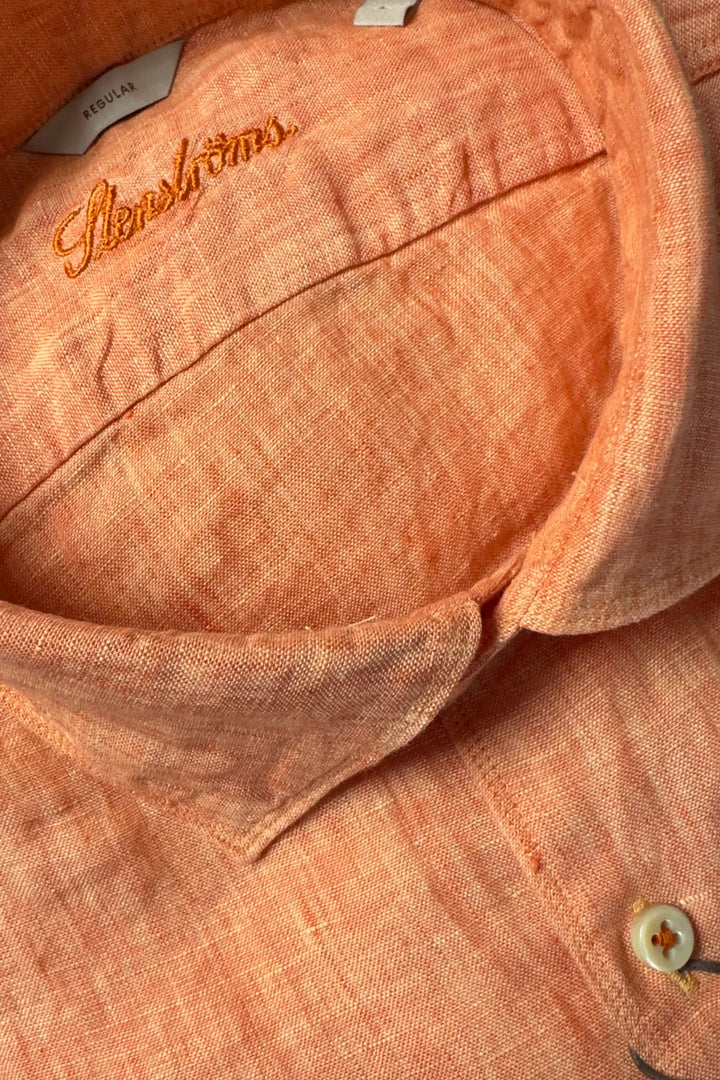 Close-up of a peach-colored shirt with 'Fleischmann's' branding on the collar.