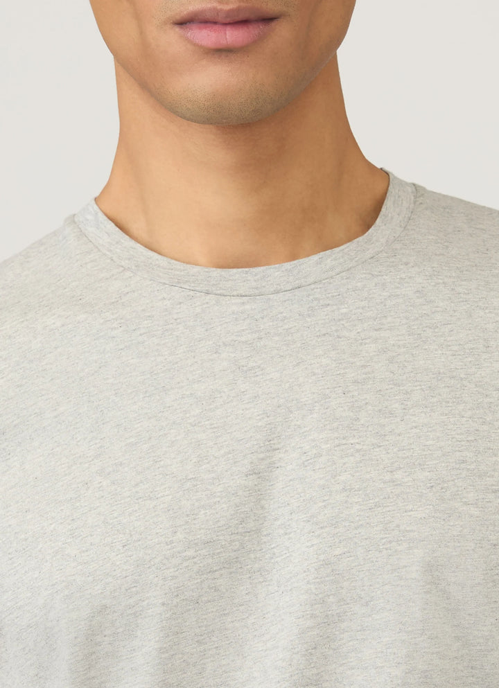 Close-up of a person wearing a light gray sweater against a neutral background