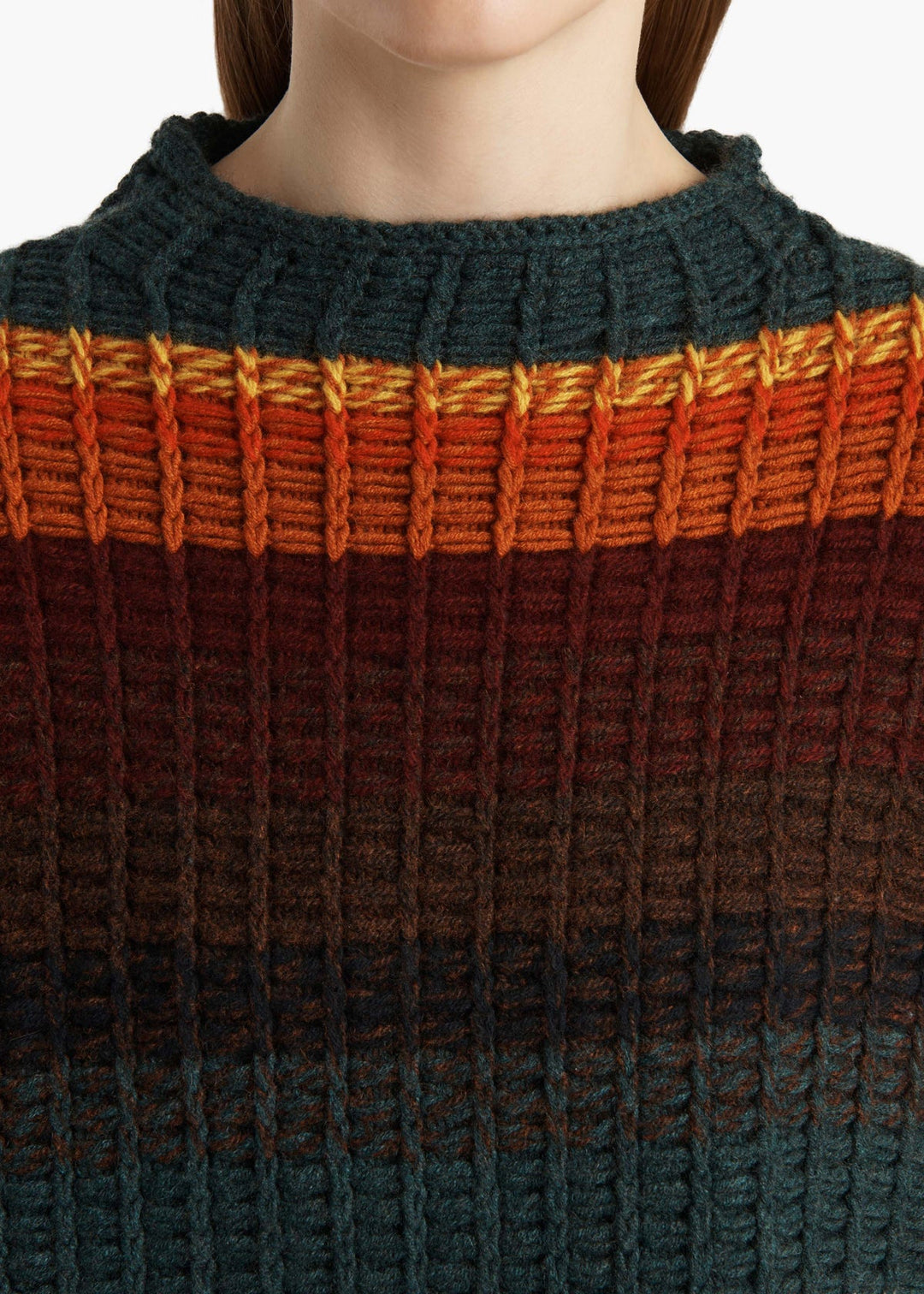 Close-up of a person wearing a sweater with a gradient pattern from orange to green.