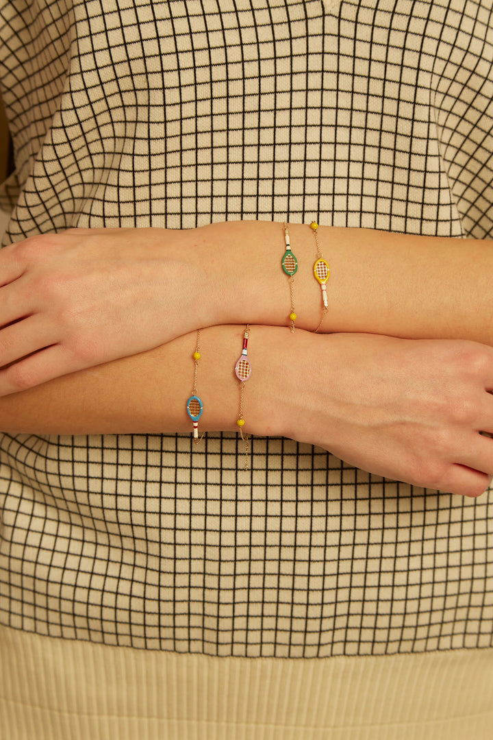 Close-up of a person wearing multiple bracelets on a checkered fabric background