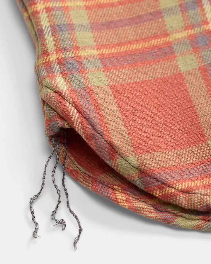 Close-up of a plaid fabric drawstring bag on a light gray background