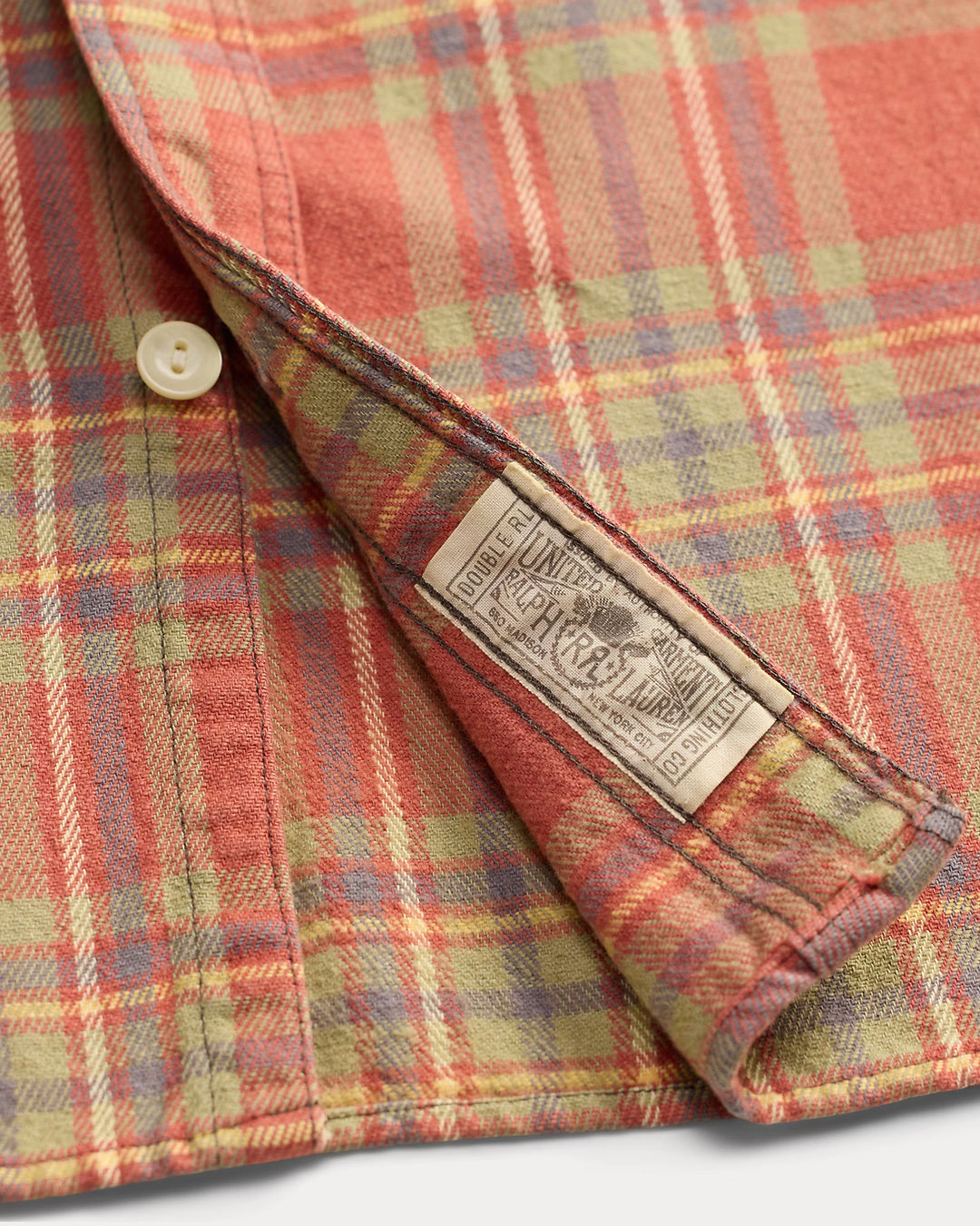 Close-up of a plaid fabric with a brand label on a white background