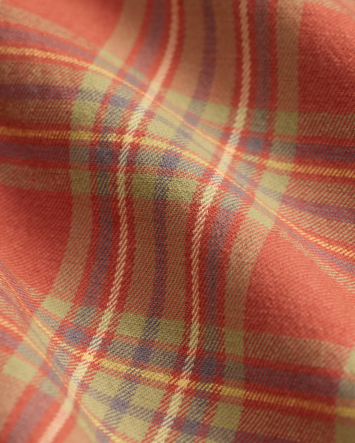 Close-up of a plaid fabric with red, yellow, and blue colors.