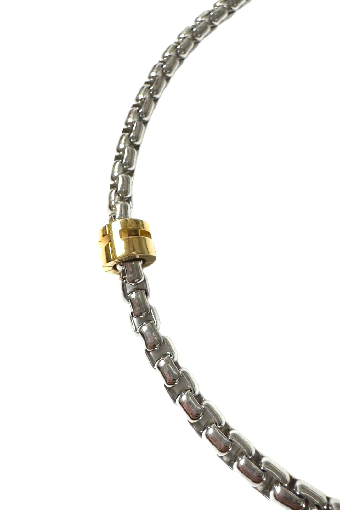 Close-up of a silver chain with a gold clasp on a white background