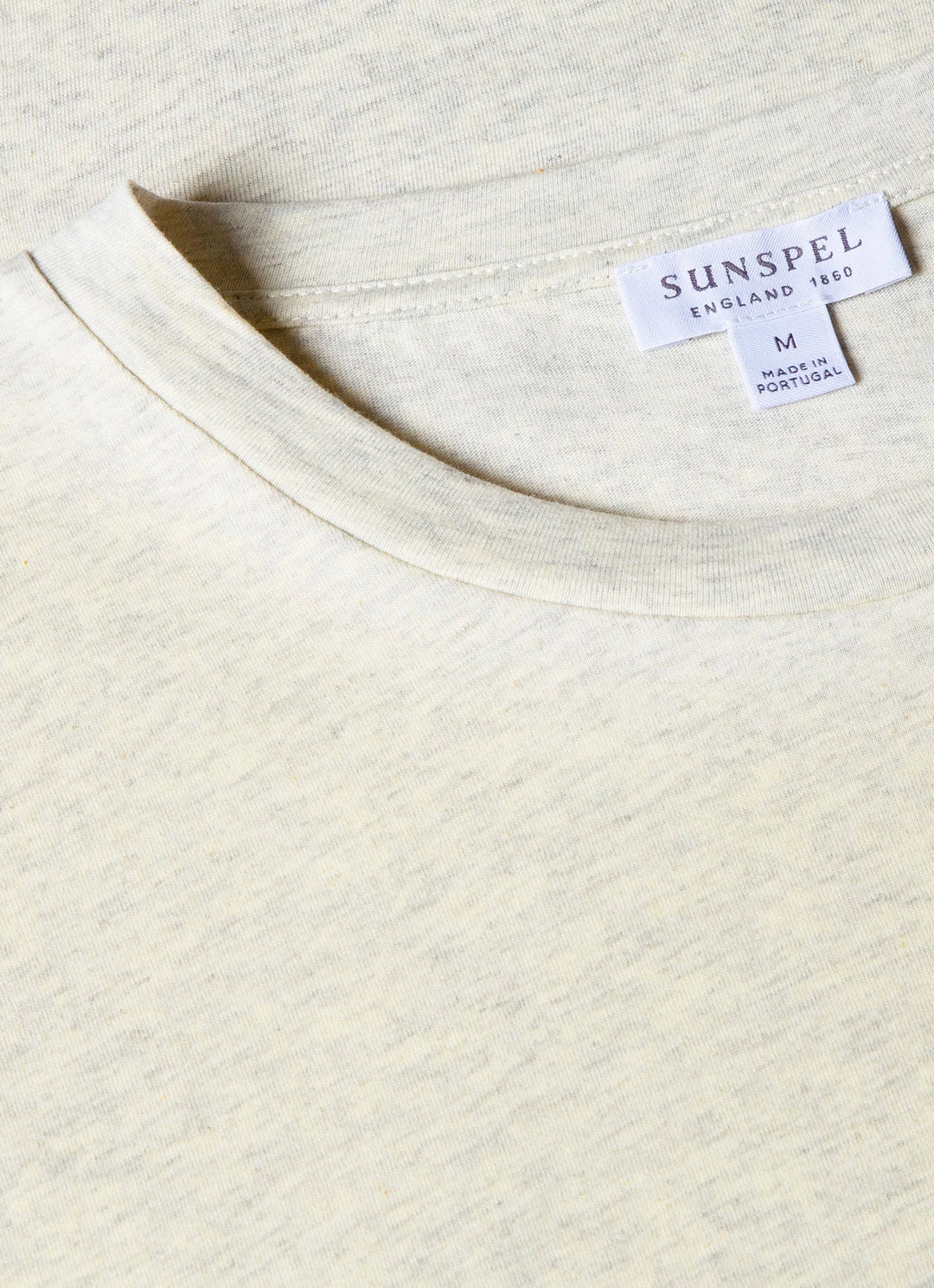 Close-up of a Sunspel label on a white fabric background