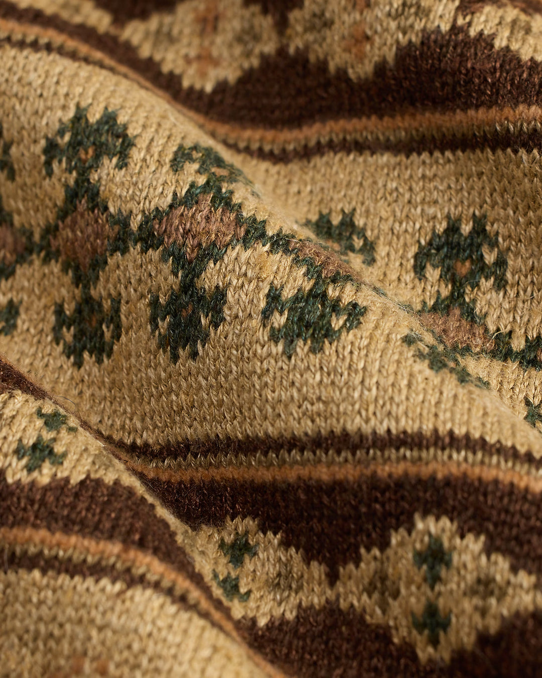 Close-up of a textured fabric with geometric pattern in earthy tones.