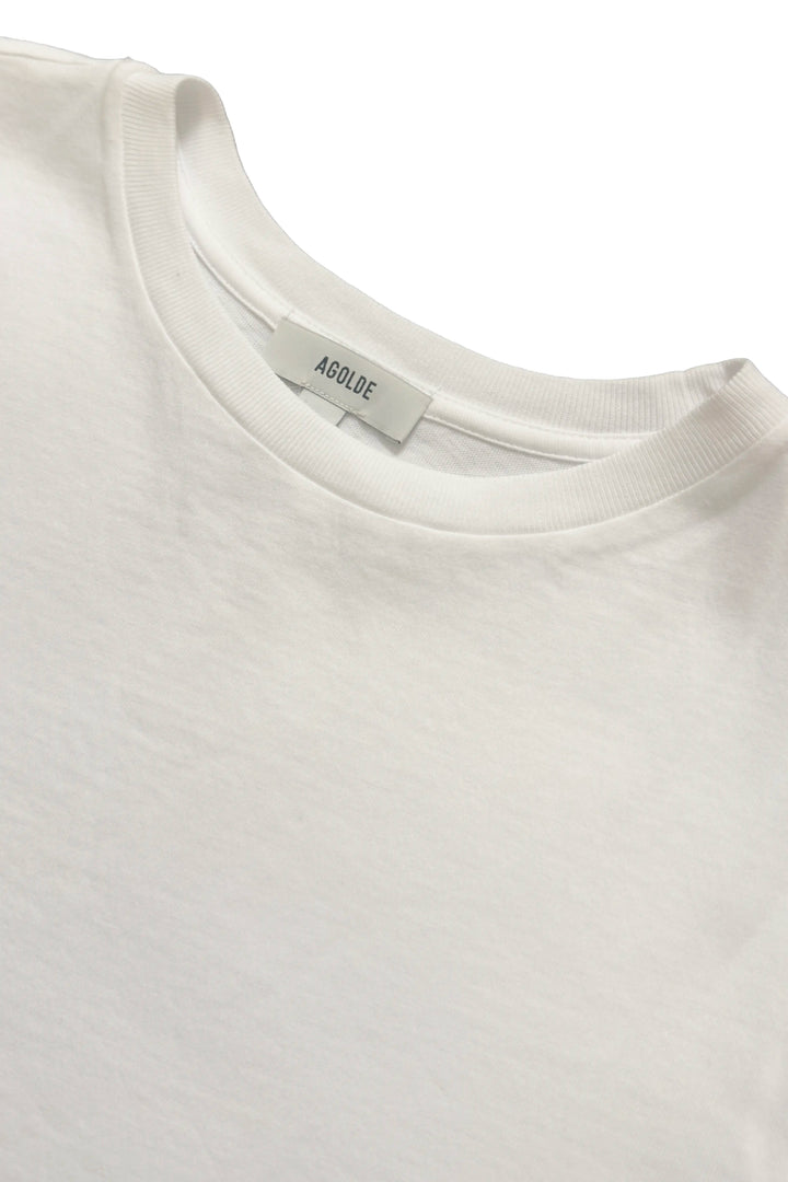 Close-up of a white t-shirt with a brand label on a white background