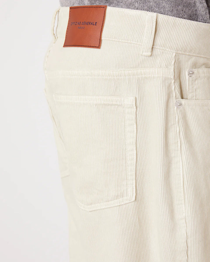 Close-up of beige corduroy pants with a leather patch on a white background