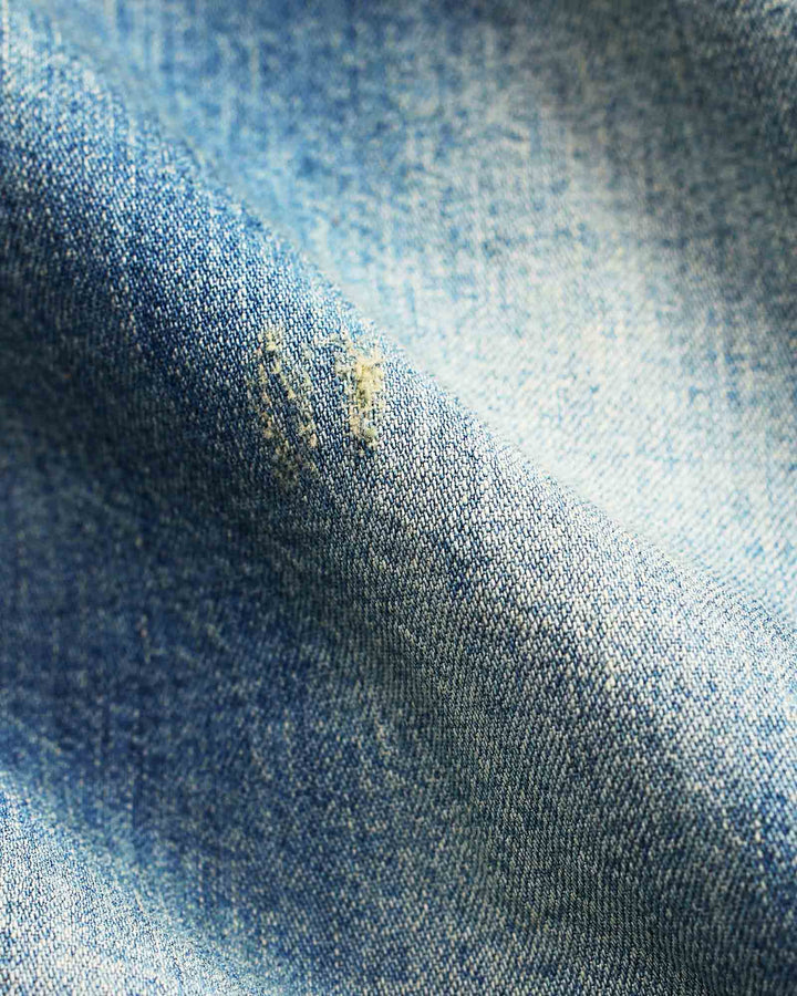 Close-up of blue denim fabric with a stain.