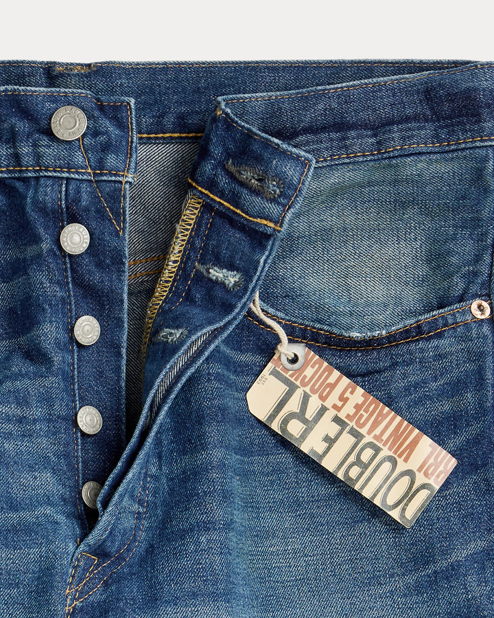 Close-up of blue denim jeans with a brand tag on the pocket.