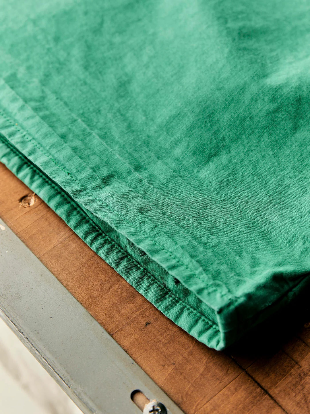 Close-up of green fabric draped over a wooden surface