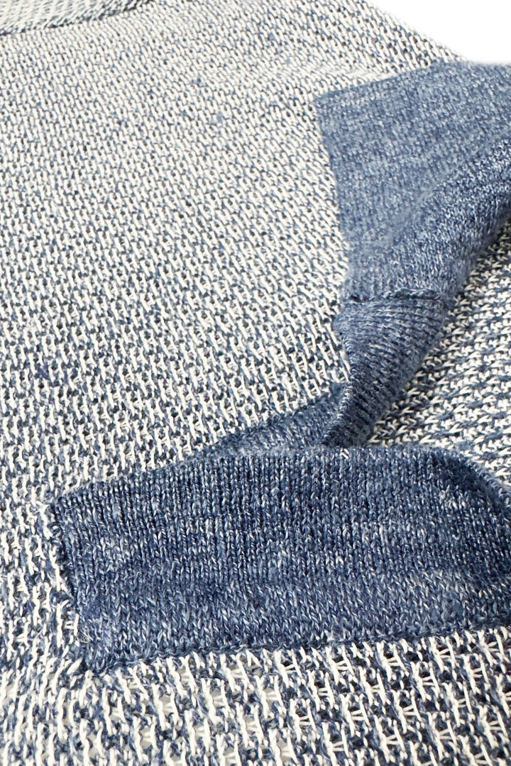 Close-up of textured fabric with a folded blue fabric piece on top
