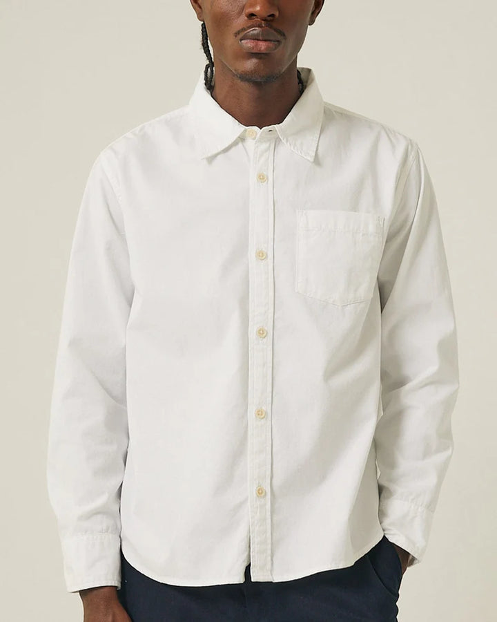 Man wearing a white button-up shirt against a plain background