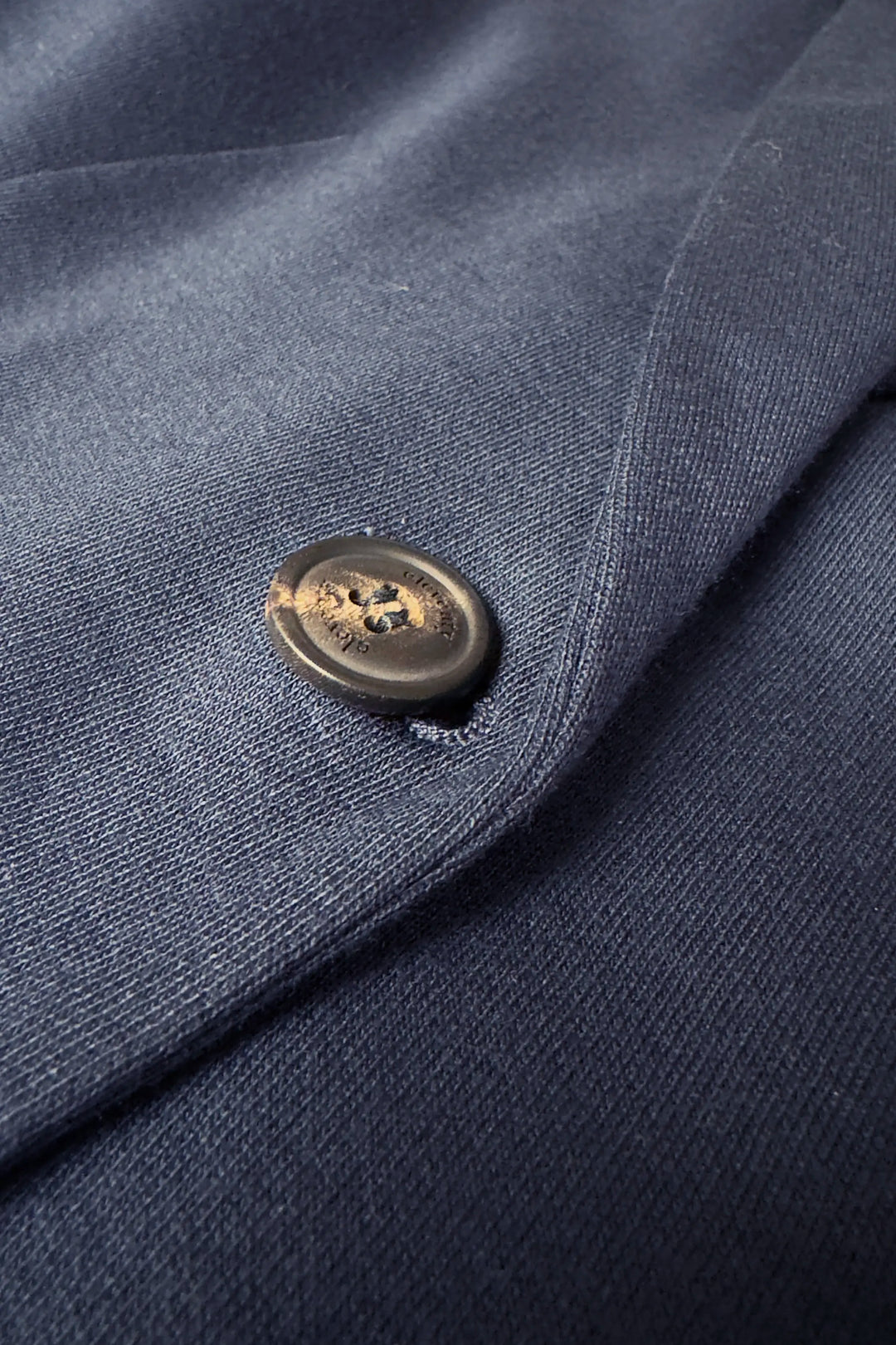 Close-up of a button on a navy blue fabric