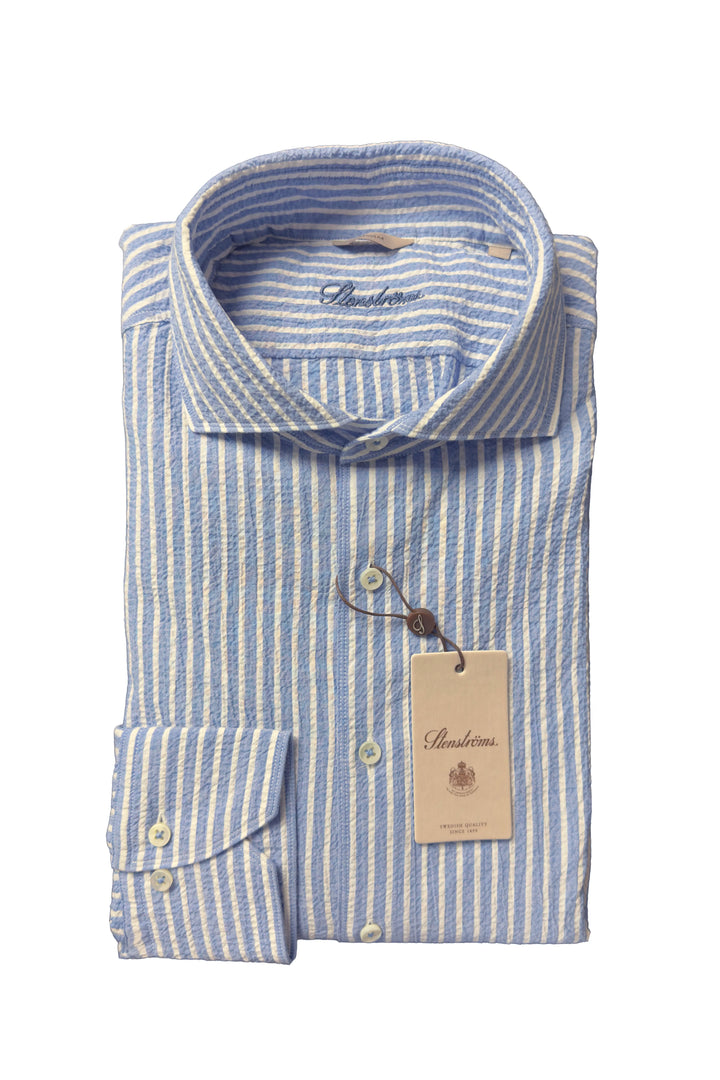 Folded blue and white striped shirt with a brand tag on a white background
