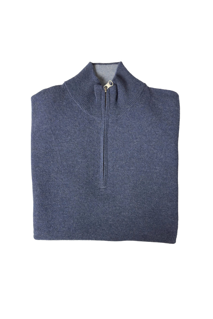 Folded blue pullover with a quarter zip on a white background