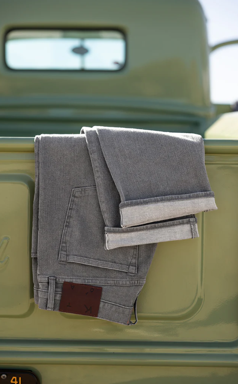 Folded gray jeans on a green vehicle