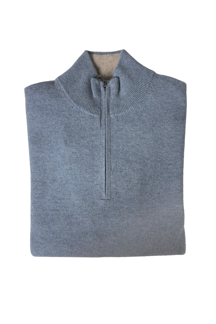 Folded gray sweater with a quarter zip on a white background