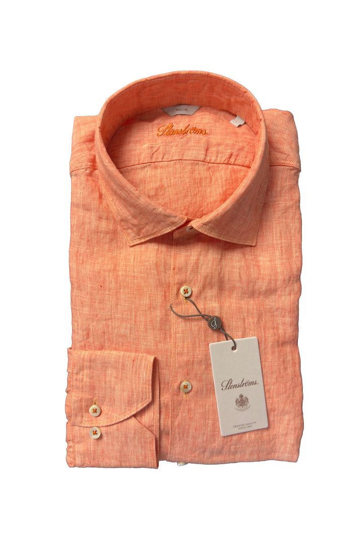 Folded orange shirt with a tag on a white background