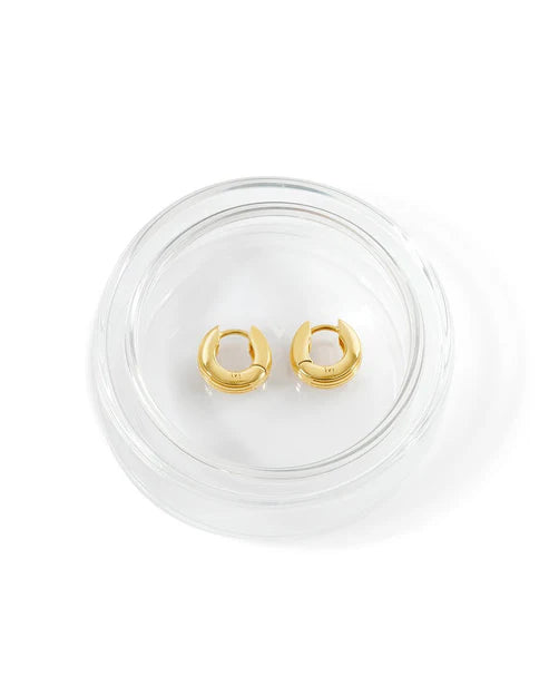 Gold hoop earrings on a clear stand against a white background