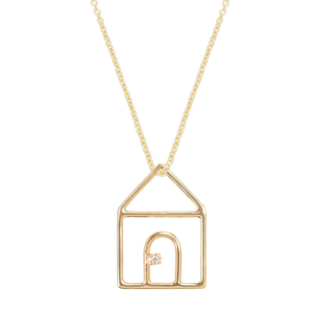 Gold necklace with a house-shaped pendant on a white background