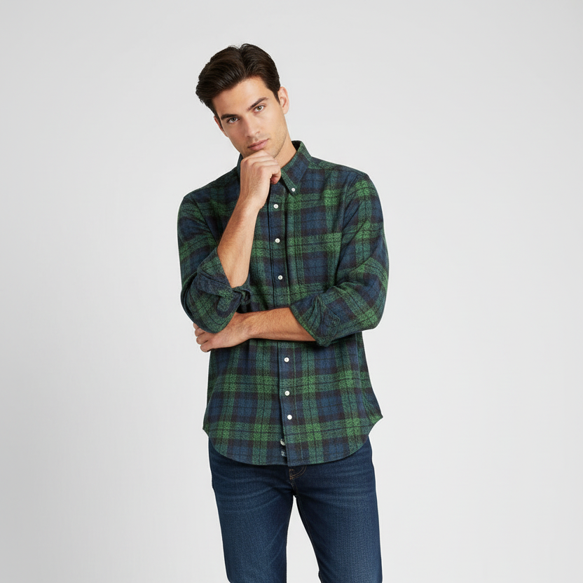 Man wearing a green plaid shirt and blue jeans on a white background