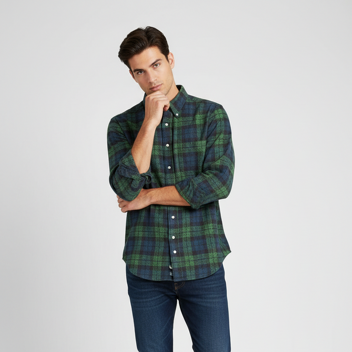 Man wearing a green plaid shirt and blue jeans on a white background