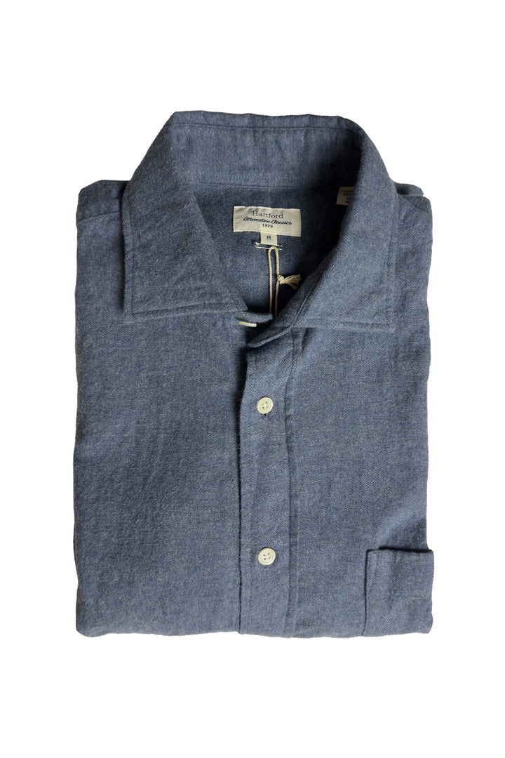 Folded blue shirt with a brand label on a white background