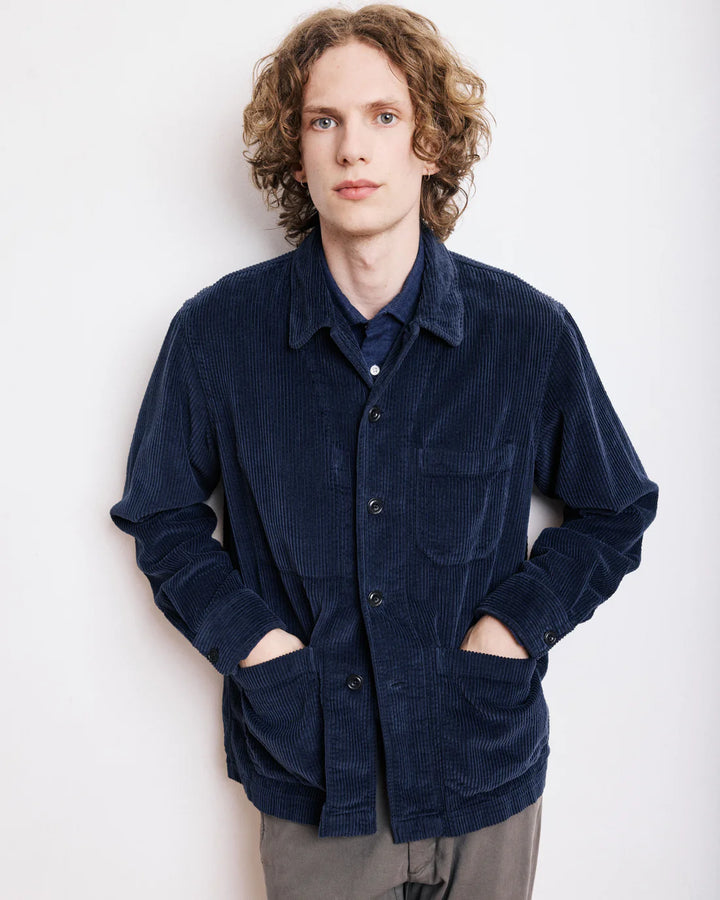 Person wearing a navy blue corduroy shirt against a white background