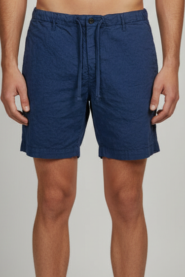 Blue shorts worn by a person on a plain background
