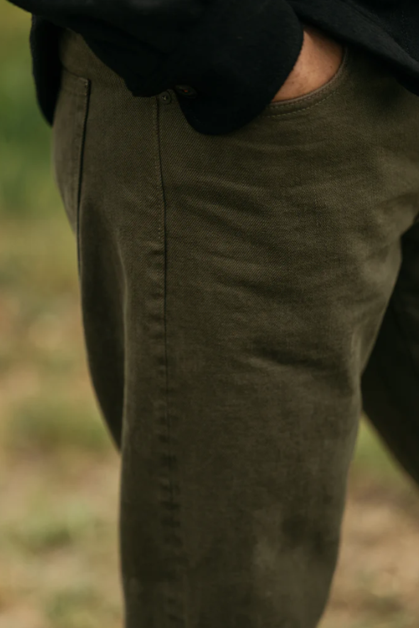 Close-up of green pants with a blurred natural background