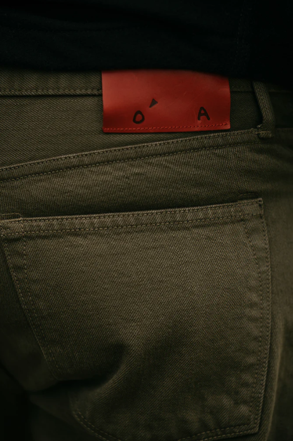 Close-up of green pants with a red label on the waistband.
