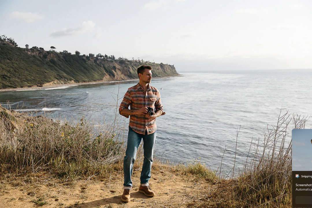 Man standing on a coastal trail with ocean view