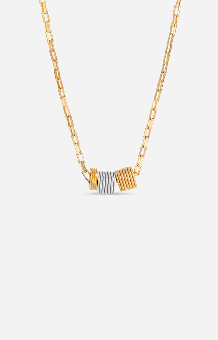 Gold and silver necklace on a light gray background