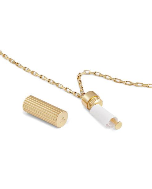 Gold necklace with cylindrical pendant on a white background