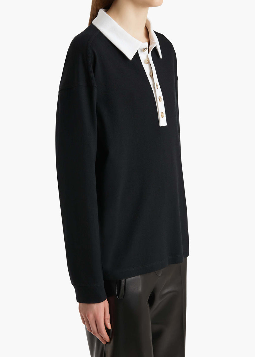 Black long-sleeve shirt with white collar and buttons on a white background