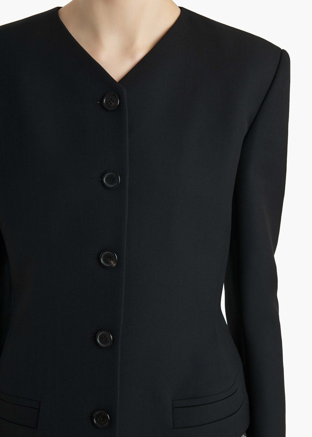 Black button-up jacket on a mannequin with a plain background
