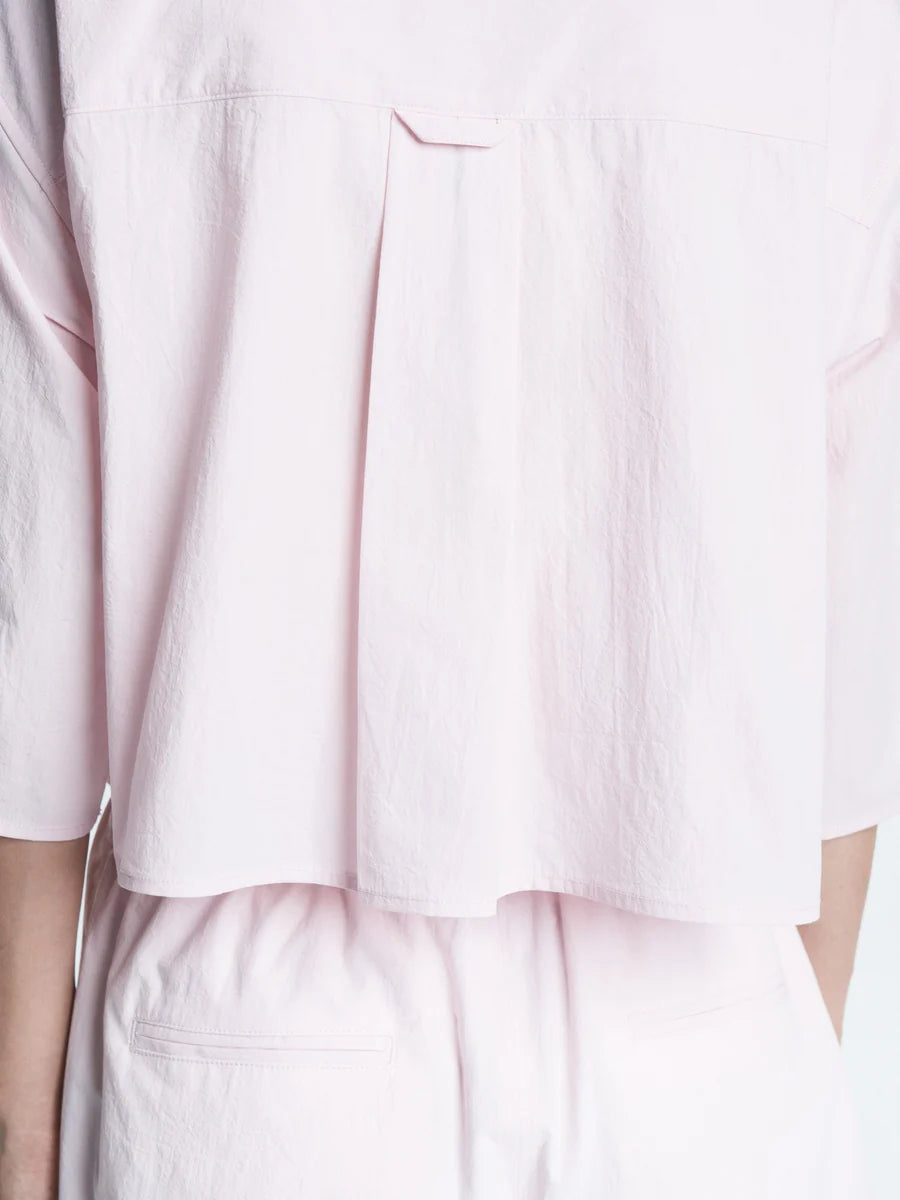 Light pink shirt and pants worn by a person on a white background