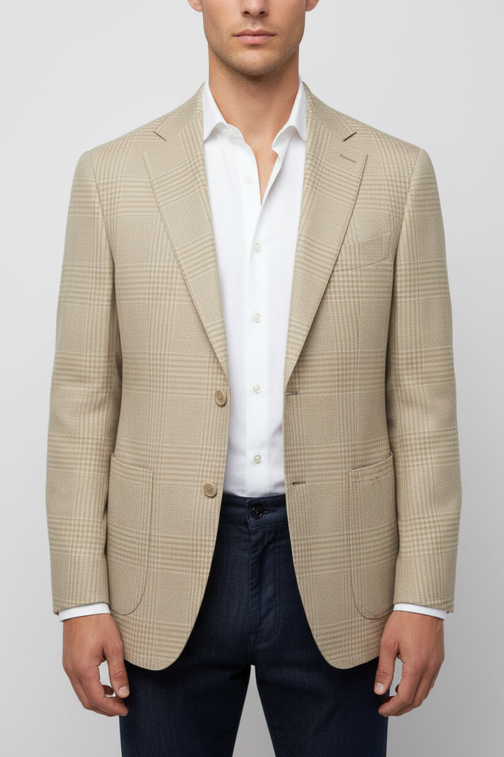 Man wearing a beige checkered blazer over a white shirt on a plain background