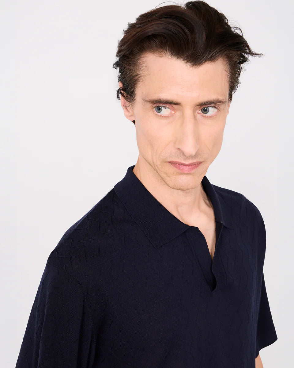 Man wearing a dark blue shirt against a white background