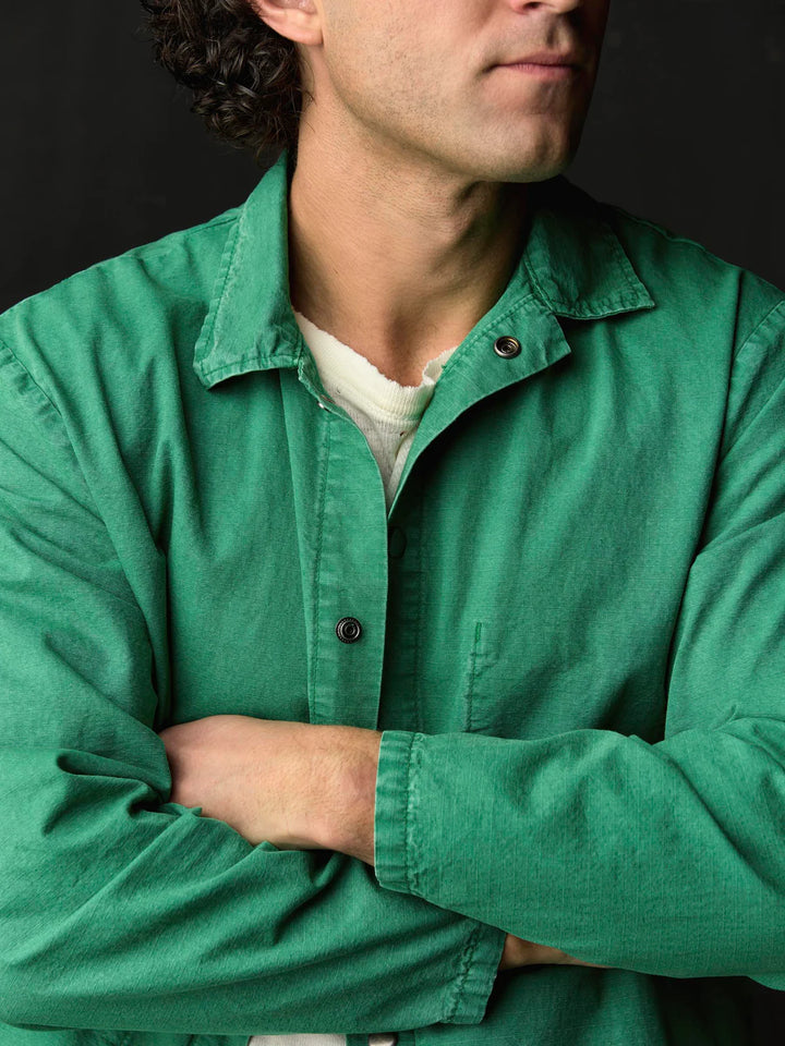 Man wearing a green jacket with a dark background