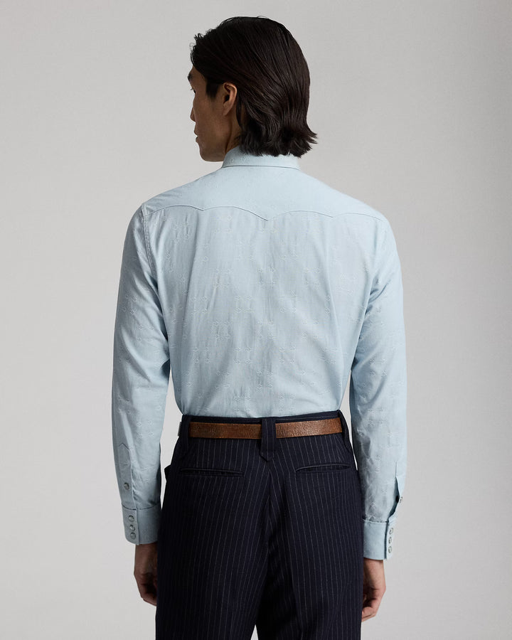 Man wearing a light blue shirt and dark pinstripe pants on a plain background